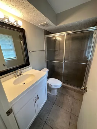 a bathroom with a granite countertop sink a toilet and a mirror