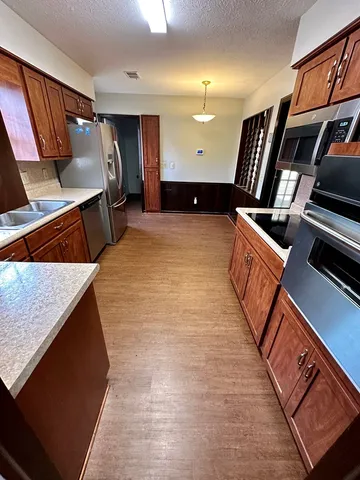 a kitchen with stainless steel appliances kitchen island granite countertop a stove a sink and a refrigerator