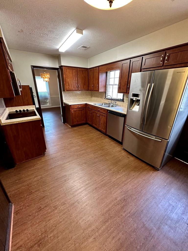 116 Whippoorwill Lane Columbus, GA 31906 - Photo 6 of 13 a kitchen with stainless steel appliances kitchen island granite countertop a refrigerator and a stove