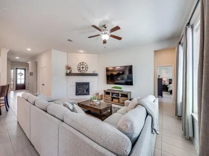 a living room with furniture a flat screen tv and a fireplace