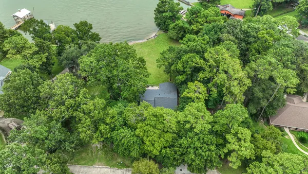 an aerial view of a house with a yard and lake view