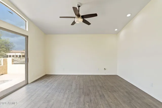 a view of an empty room with a window and wooden floor