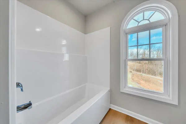 a bathroom with a bathtub and a window