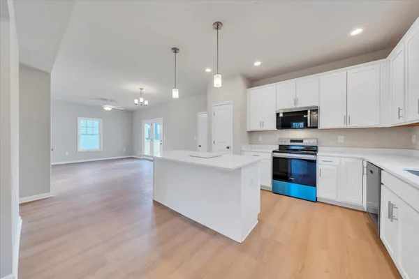 a kitchen with kitchen island a sink stainless steel appliances and cabinets
