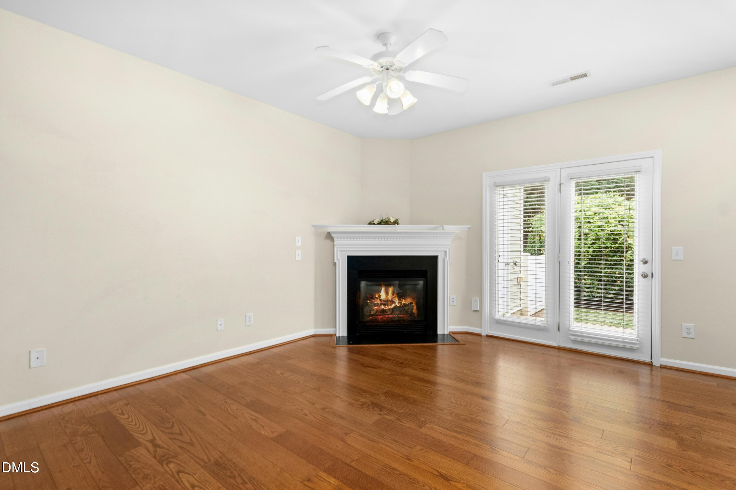 5541 Nur Lane Raleigh, NC 27606 - Photo 10 of 33 an empty room with wooden floor fireplace and windows