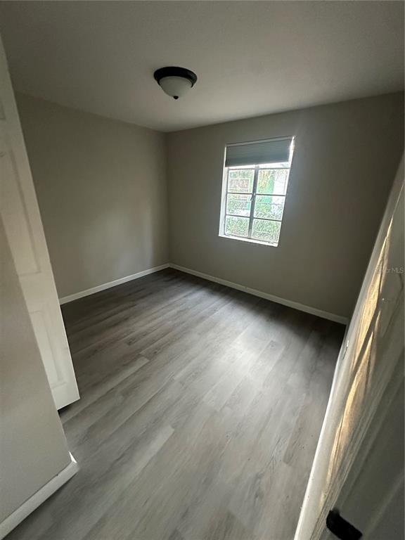 2435 North Junglecamp Road Inverness, FL 34453 - Photo 11 of 13 an empty room with wooden floor and windows