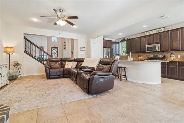 a living room with stainless steel appliances kitchen island furniture and a chandelier