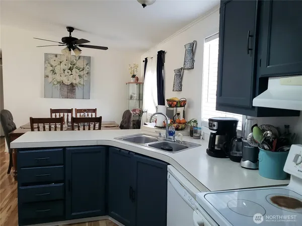 a kitchen with stainless steel appliances a refrigerator and a wooden floor