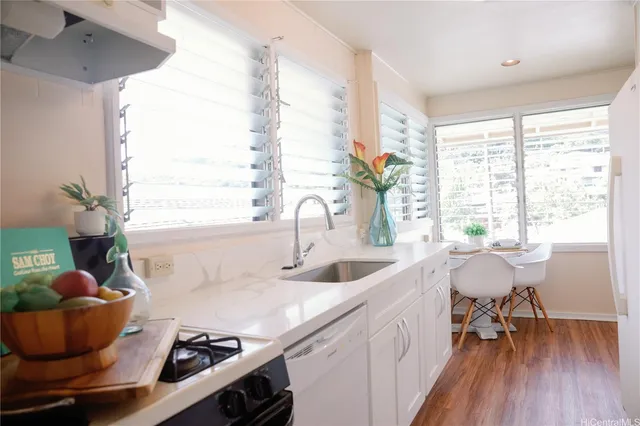 a kitchen with a sink and wooden floor