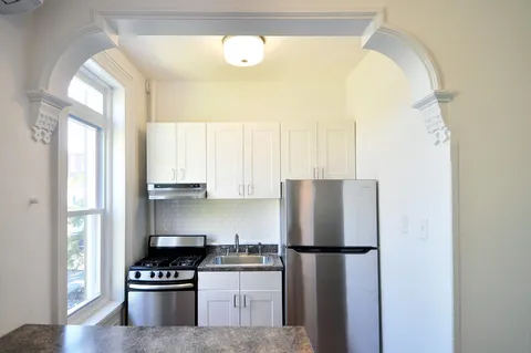 a kitchen with a refrigerator a stove and a window