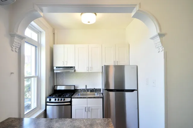 a kitchen with a refrigerator a stove and a window