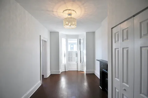 a view of an empty room with a fireplace and a window