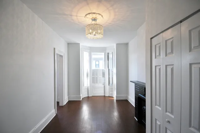 a view of an empty room with a fireplace and a window