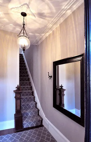 a view of a hallway with wooden floor and staircase