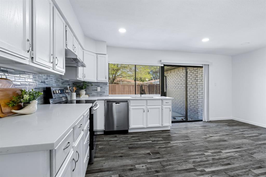 3429 Post Oak Road Garland, TX 75044 - Photo 17 of 36 a kitchen with a sink a stove cabinets and wooden floor