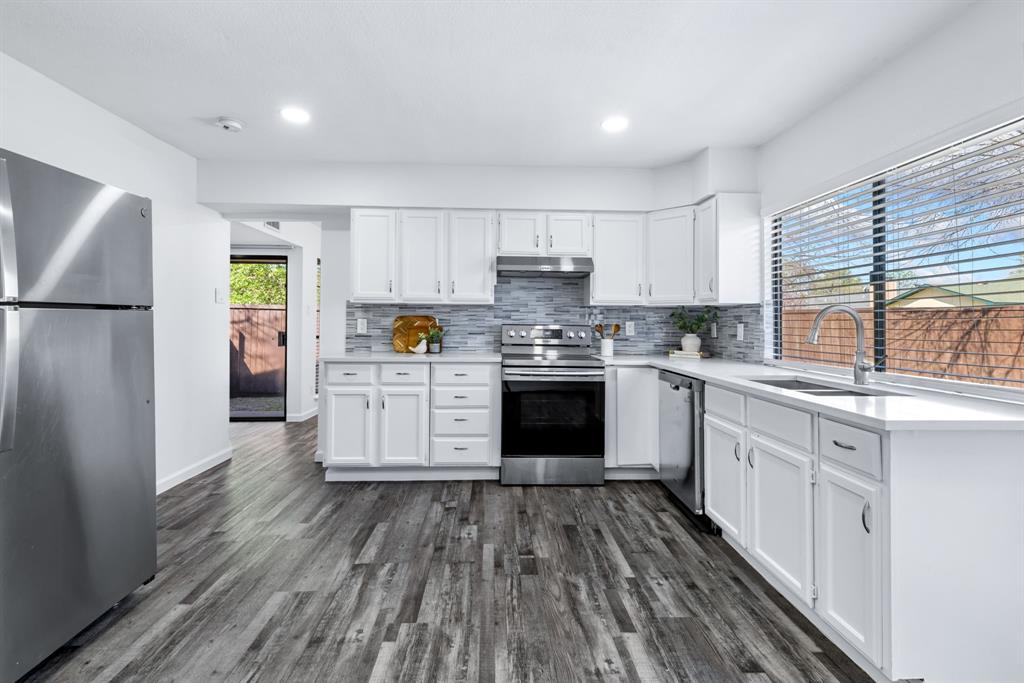 3429 Post Oak Road Garland, TX 75044 - Photo 18 of 36 a kitchen with wooden floors and white stainless steel appliances