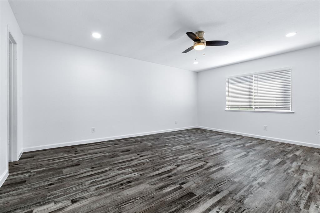 3429 Post Oak Road Garland, TX 75044 - Photo 25 of 36 an empty room with wooden floor ceiling fan and windows