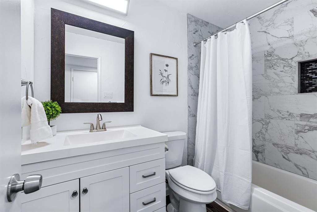 3429 Post Oak Road Garland, TX 75044 - Photo 30 of 36 a bathroom with a sink a toilet and shower curtain