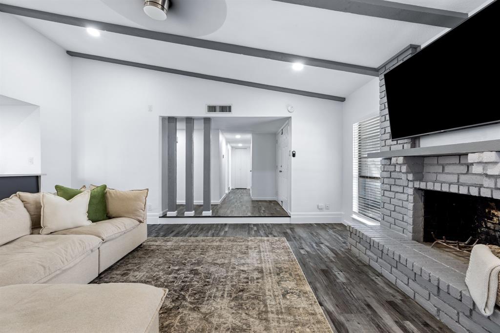 3429 Post Oak Road Garland, TX 75044 - Photo 7 of 36 a living room with furniture a flat screen tv and a fireplace