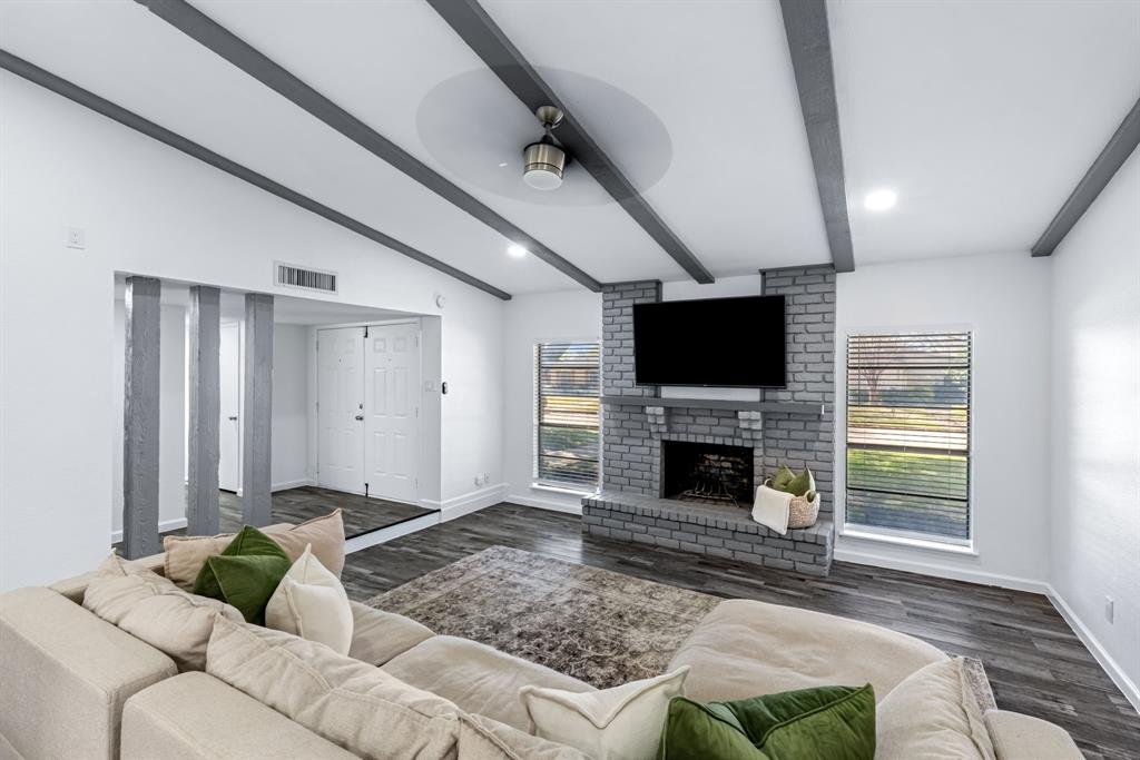 3429 Post Oak Road Garland, TX 75044 - Photo 8 of 36 a living room with furniture a flat screen tv and a fireplace