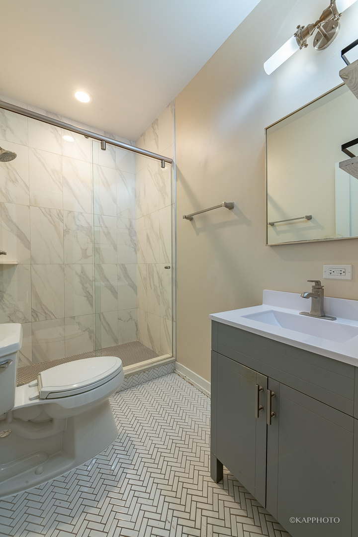 1141 West Madison Street, Unit 3 Chicago, IL 60607 - Photo 19 of 34 a bathroom with a granite countertop sink toilet and shower