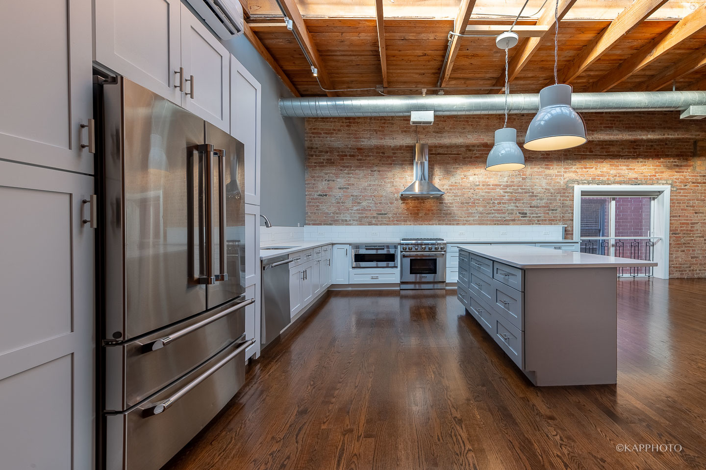 1141 West Madison Street, Unit 3 Chicago, IL 60607 - Photo 7 of 34 a kitchen with stainless steel appliances granite countertop a refrigerator a oven and a stove with wooden floors