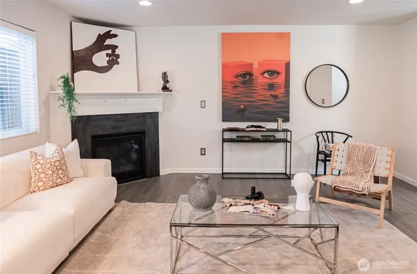 a living room with furniture a fireplace and wall paintings