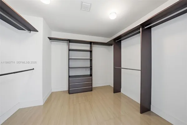 a large kitchen with granite countertop a sink and white cabinets