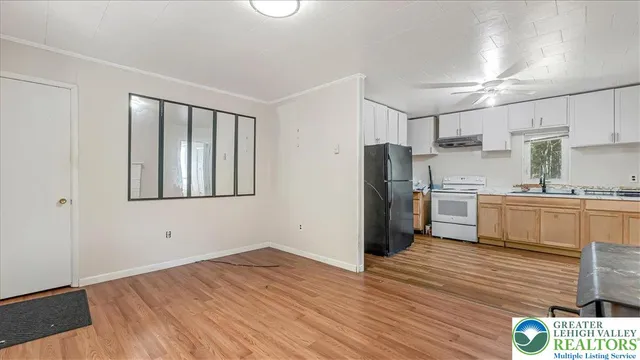 a kitchen with wooden floors and refrigerator