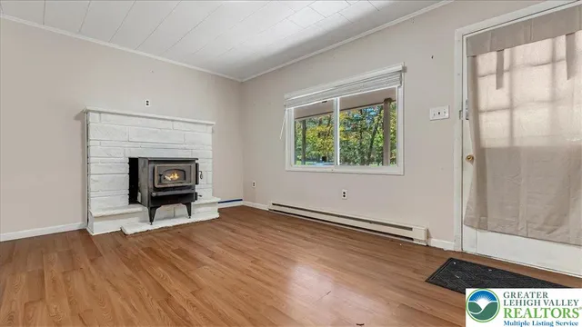 an empty room with windows a fireplace and wooden floor
