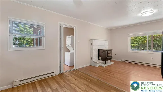 a view of a room with wooden floor fireplace and windows