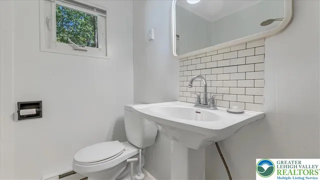 a bathroom with a sink a toilet and mirror