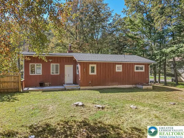 a view of a yard in front of a house with large tree
