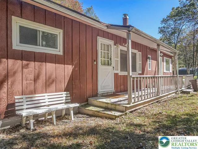 an aerial view of residential house with outdoor space and covered by trees