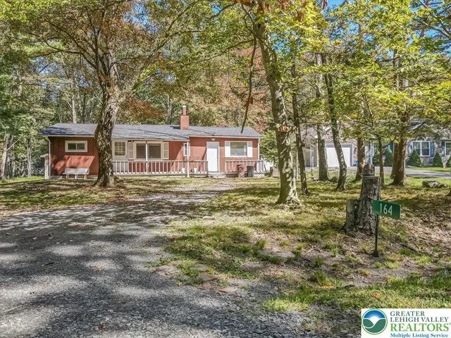 an aerial view of residential house with outdoor space and trees all around