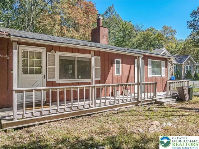 a view of a house with a small yard and wooden fence