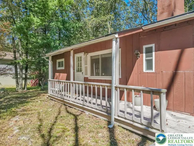 a view of a house with backyard and deck