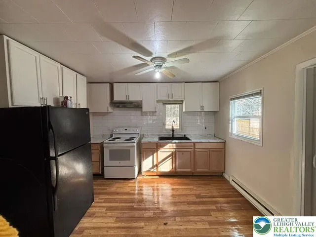 a kitchen with stainless steel appliances granite countertop a refrigerator a stove a sink and a microwave