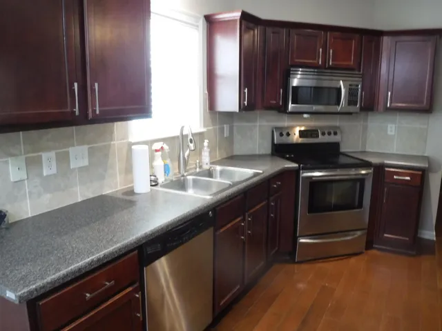 a kitchen with sink a microwave a stove and cabinets