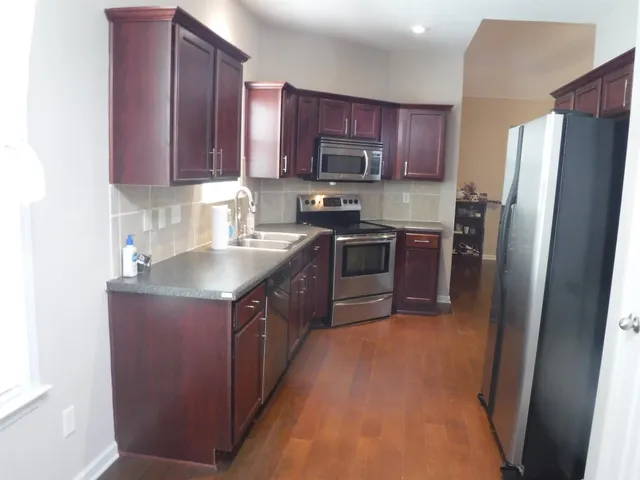 a kitchen with stainless steel appliances granite countertop wooden cabinets a stove top oven a sink and dishwasher