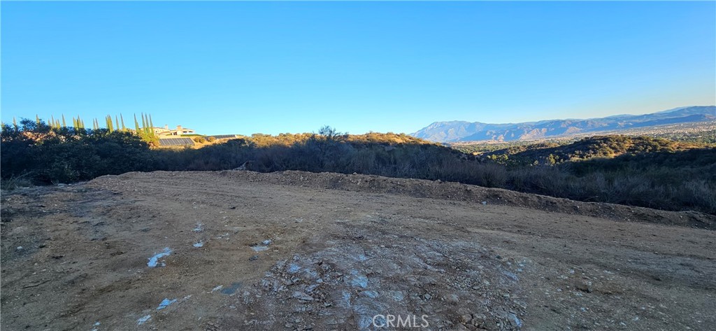 a view of a dry yard with mountains in the background