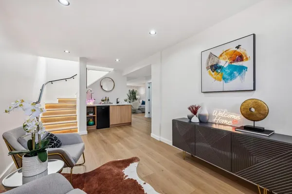 a living room with furniture kitchen view and a potted plant