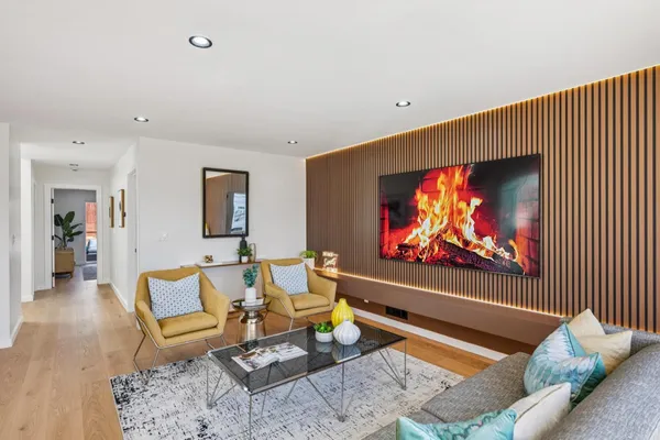 a living room with furniture a potted plant and a flat screen tv