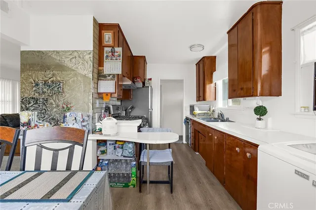 a large kitchen with a table chairs wooden floor and a large window