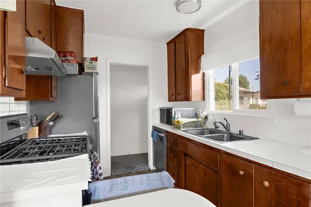a kitchen with stainless steel appliances a sink stove and cabinets