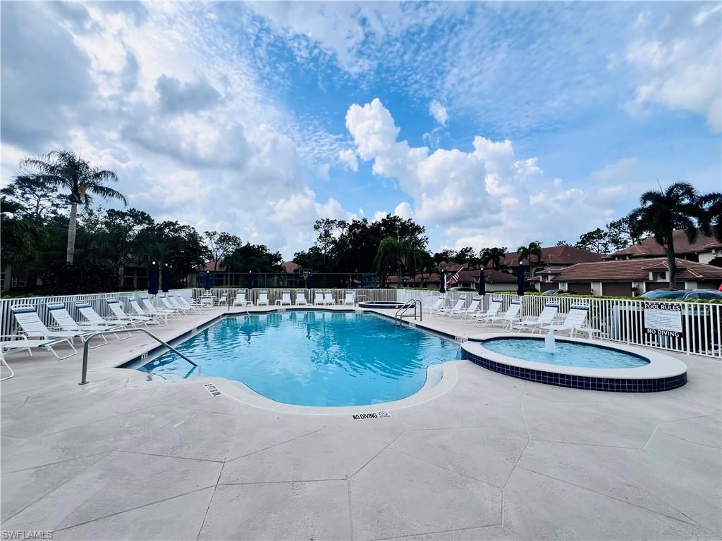 8073 Panther Trail, Unit 1404 Naples, FL 34113 - Photo 27 of 29 a view of a swimming pool with a table and chairs