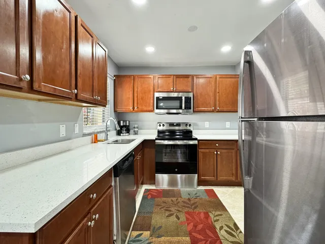 a kitchen with stainless steel appliances granite countertop a refrigerator sink and microwave