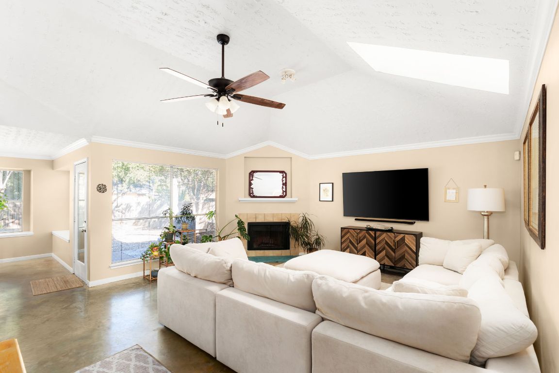 1412 Pigeon Forge Road Pflugerville, TX 78660 - Photo 2 of 20 a living room with furniture a fireplace and a flat screen tv