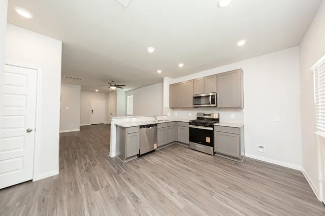 a kitchen with a refrigerator and a stove top oven