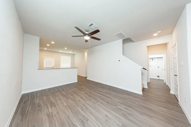 a view of a big room with wooden floor and a ceiling fan